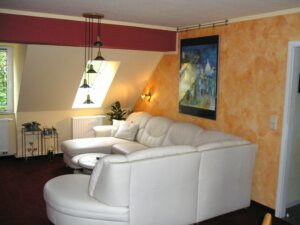 eingerichtetes Dachgeschoss mit getupfter Wand